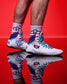 White USA Wrestling Shoes with blue and red accents on a red background