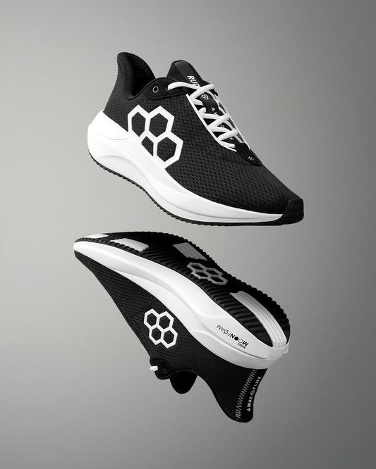Black and white running shoes with a geometric design on a gray background
