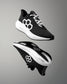 Black and white running shoes with a geometric design on a gray background