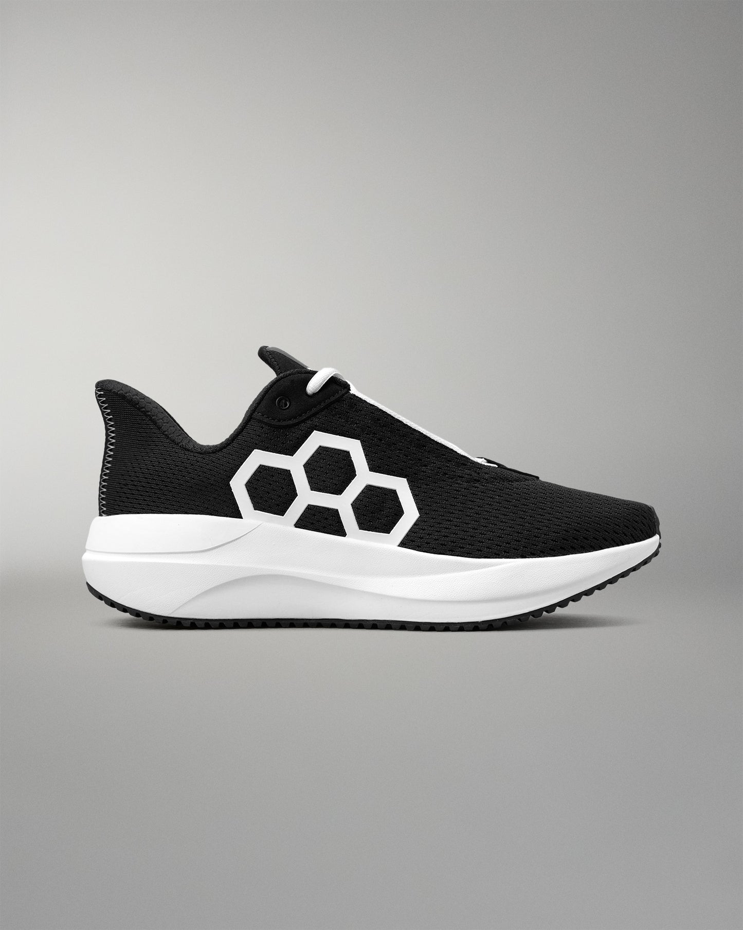 Black and white athletic shoe with a geometric design on a gray background