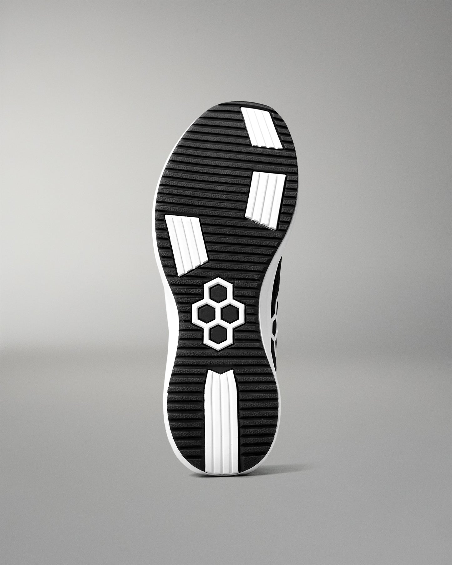 Black and white shoe sole with a hexagonal pattern on a gray background