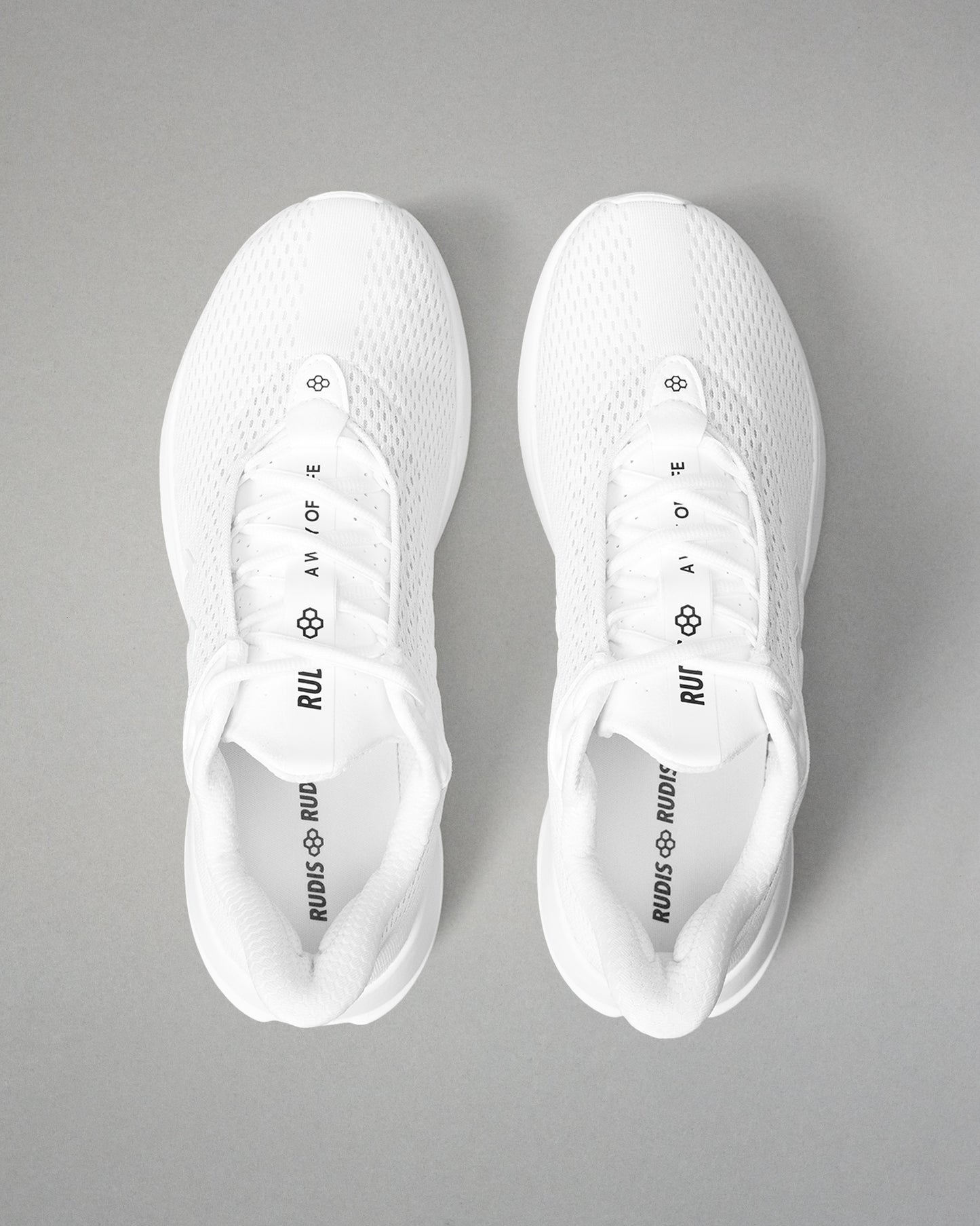 White sneakers with brand logos on a gray background