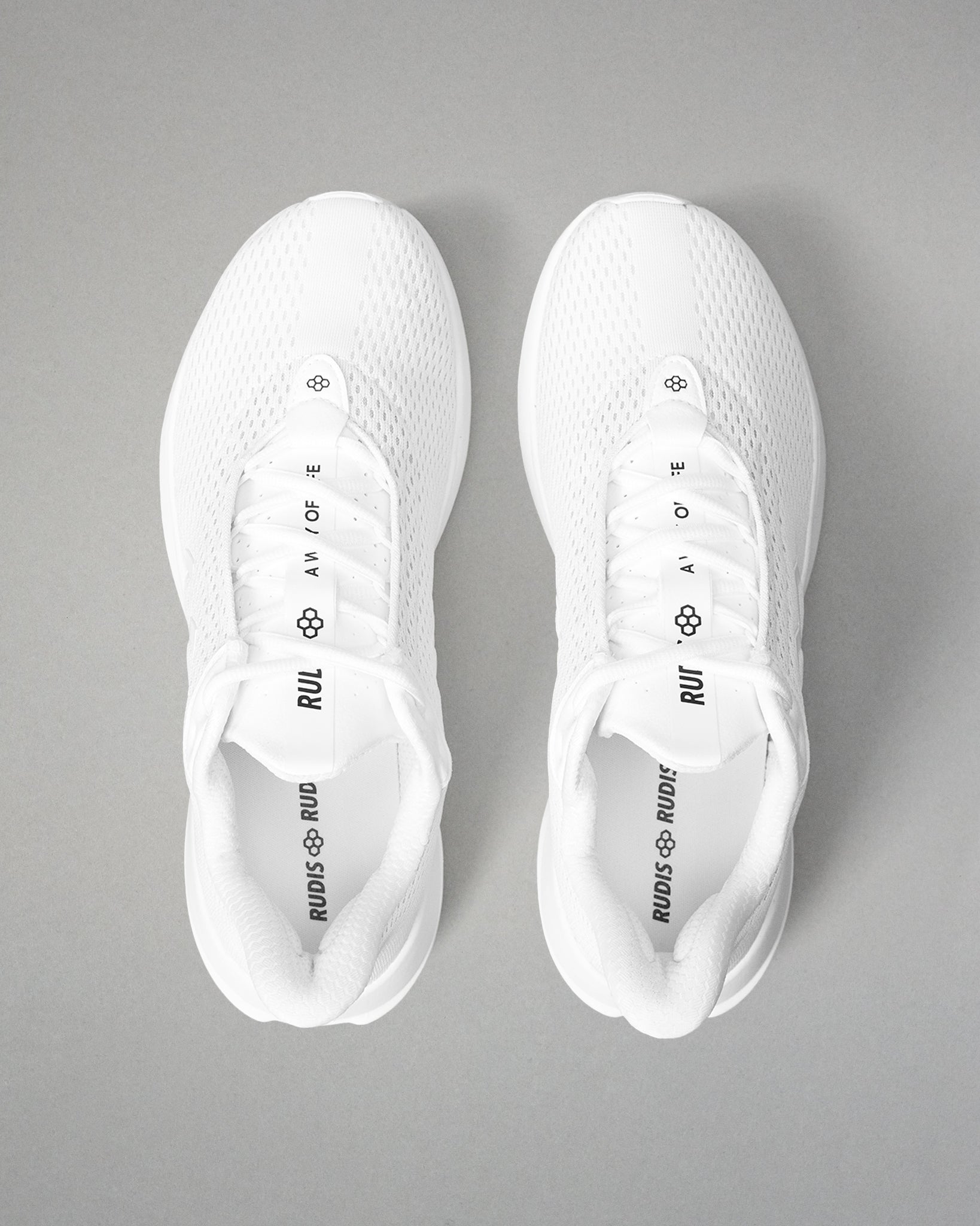 White sneakers with brand logos on a gray background