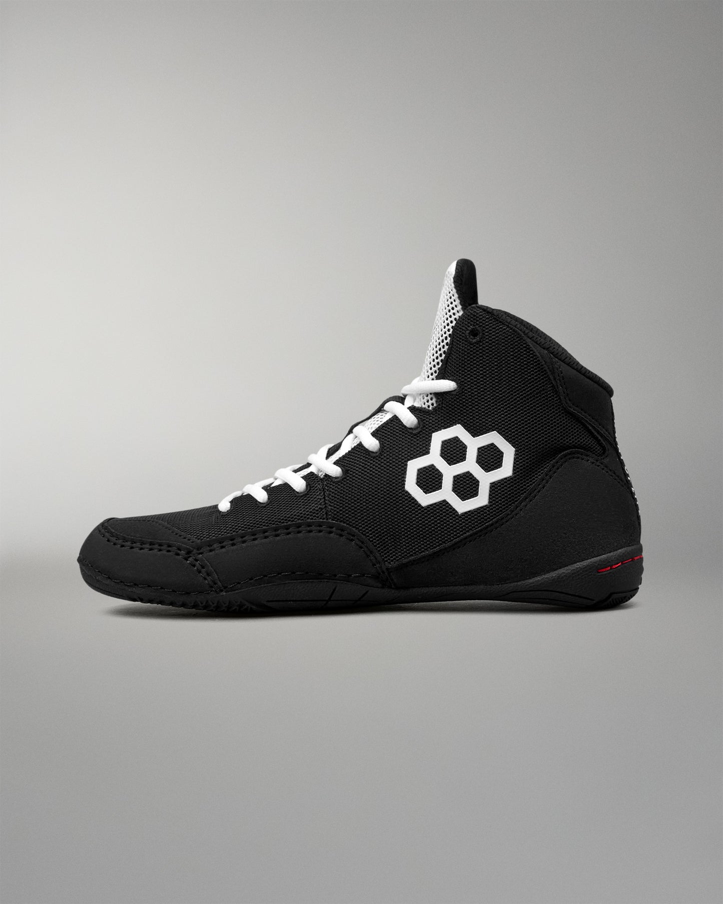 Black wrestling shoe with RUDIS branding on a light gray background