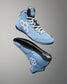 A pair of light blue high-top wrestling shoes with white laces, white geometric side logos, and black soles, shown floating against a gray gradient background.
