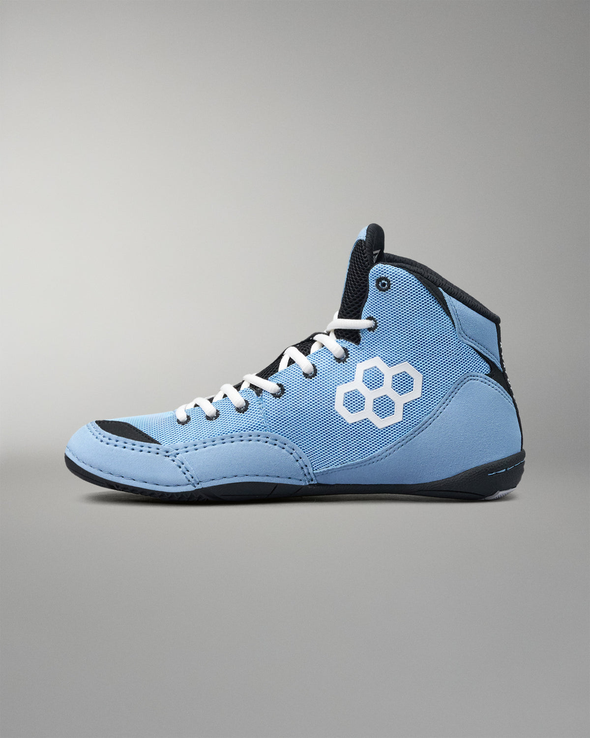 A light blue high-top wrestling shoe with a white geometric hexagon logo on the side, black accents, and white laces, shown against a neutral gray background.