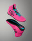 A pair of high-top athletic wrestling shoes in bright pink, shown from the side and sole views against a neutral gray gradient background. The shoes feature black geometric side logos, turquoise laces, and a black and turquoise outsole.