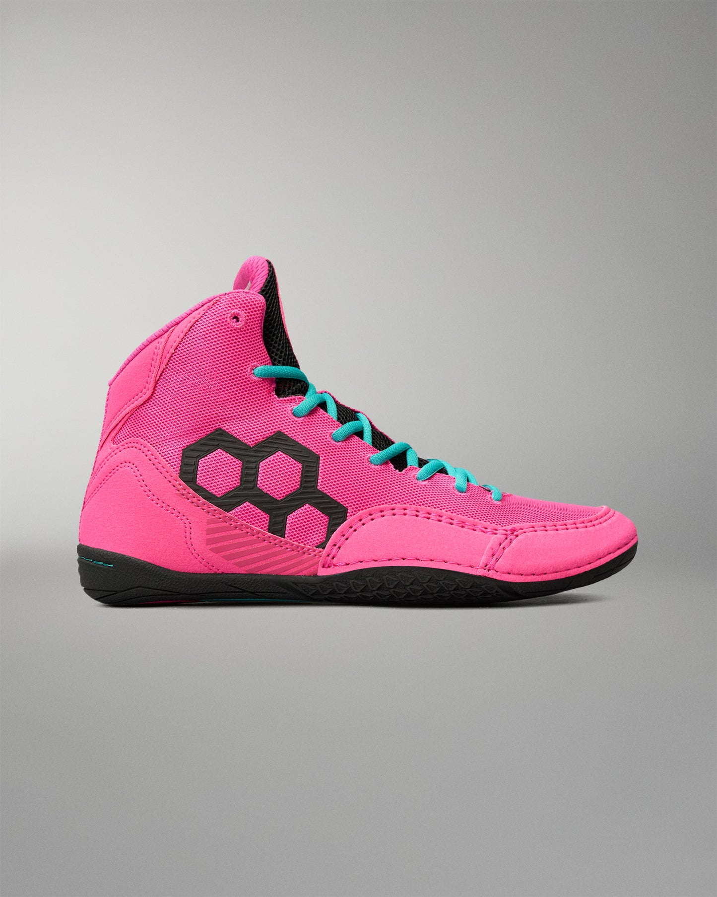 A high-top wrestling shoe in vibrant pink with a black geometric hexagon logo on the side, turquoise laces, and a black sole, shown against a neutral gray background.