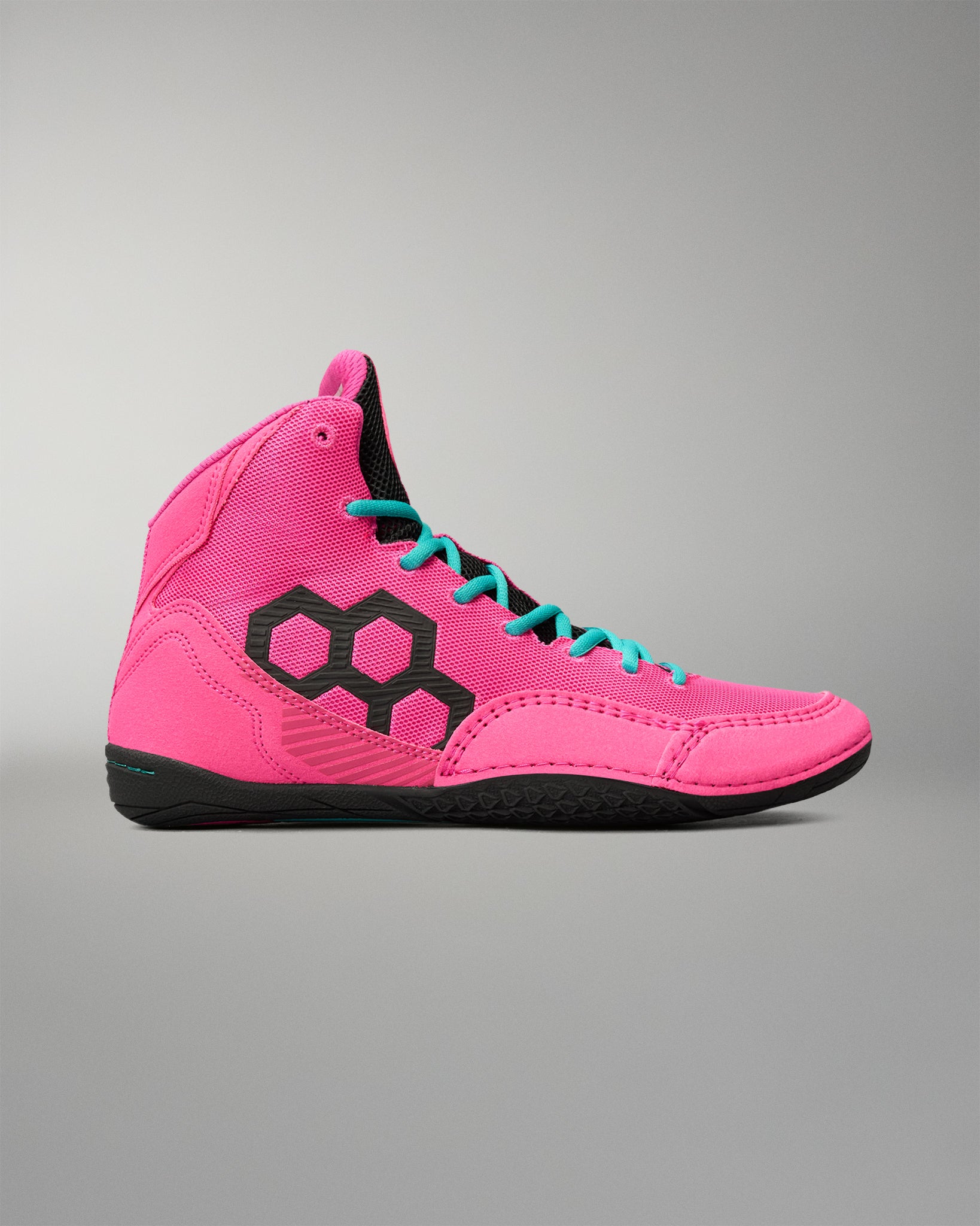 A high-top wrestling shoe in vibrant pink with a black geometric hexagon logo on the side, turquoise laces, and a black sole, shown against a neutral gray background.