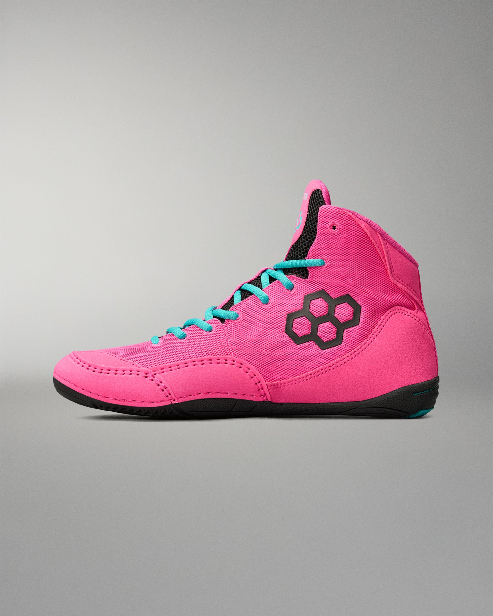 A high-top wrestling shoe in bright pink with turquoise laces, a black hexagonal logo on the side, and a black sole, shown against a neutral gray background.