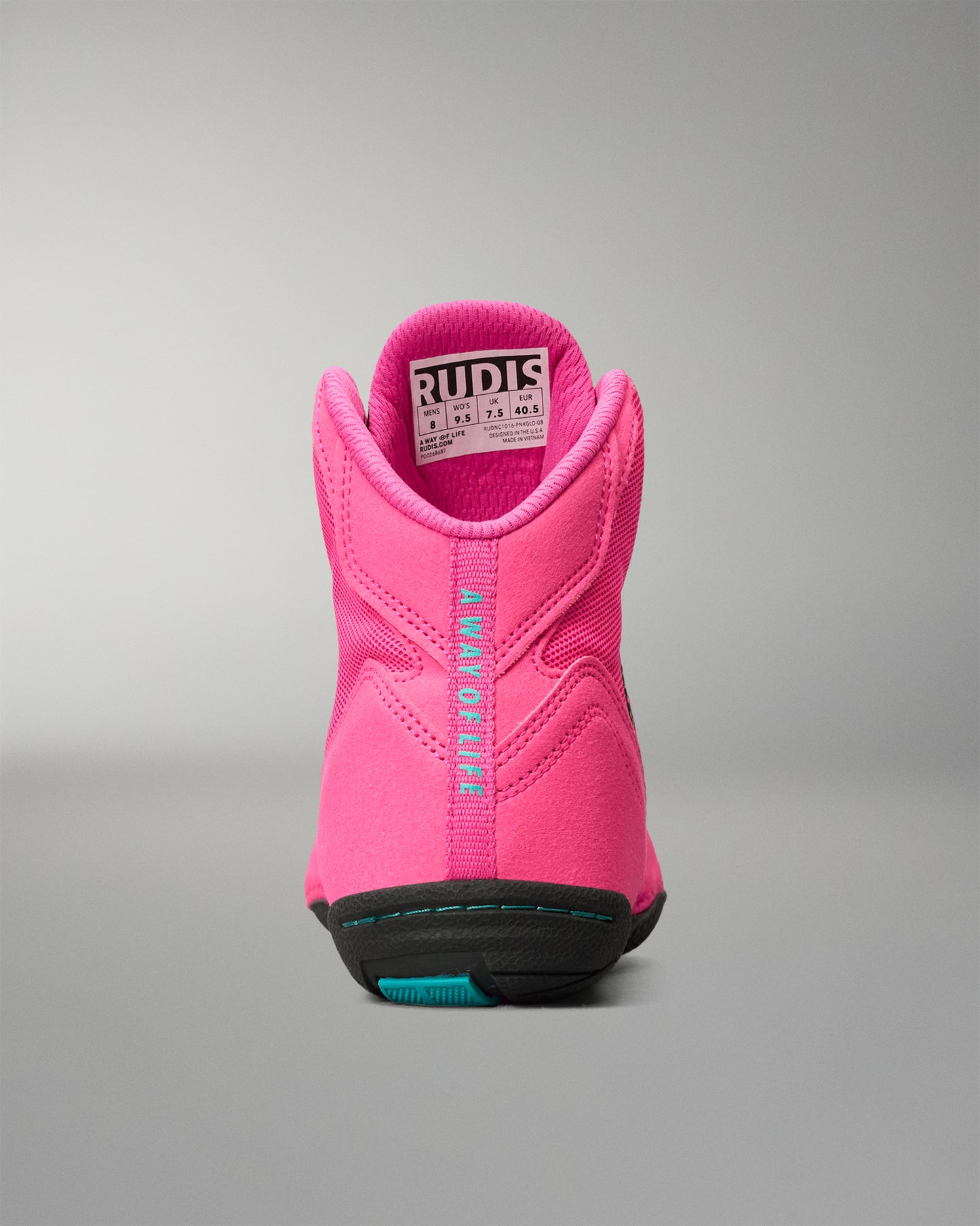 A bright pink high-top wrestling shoe shown from the back, featuring a black and teal outsole and a visible RUDIS brand label on the collar, set against a neutral gray background.