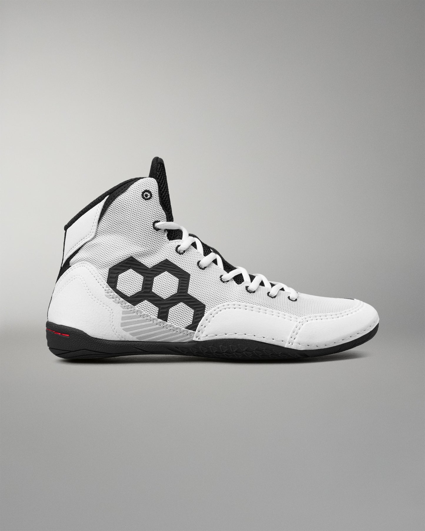 A white high-top wrestling shoe with black accents, featuring a large black geometric pattern on the side, white laces, and a black outsole, shown against a neutral gray background.