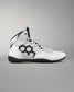 A white high-top wrestling shoe with black accents, featuring a large black geometric pattern on the side, white laces, and a black outsole, shown against a neutral gray background.