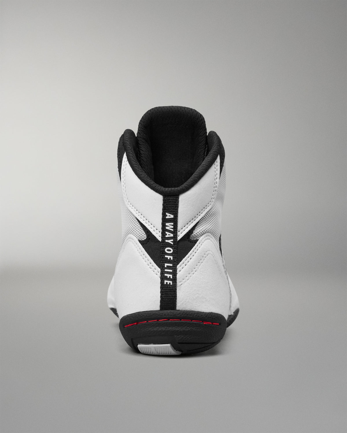 A high-top wrestling shoe shown from the back, featuring a white leather and mesh upper with black accents, including a black heel tab with the vertical text 'A WAY OF LIFE' and a black outsole.