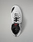 A single white and black wrestling shoe shown from a top-down view on a neutral gray background. The shoe features a white upper with black accents, white laces, and a black heel counter with a red logo and the brand name 'RUDIS'.