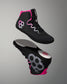 A pair of black high-top wrestling shoes with bright pink and silver accents, shown from the side and sole views against a neutral gray background.