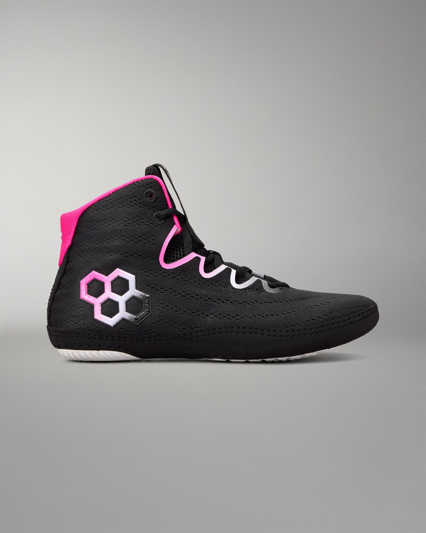 A black high-top wrestling shoe with a bright pink collar lining and a pink-and-white hexagonal logo on the side, shown against a neutral gray background.