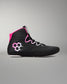 A black high-top wrestling shoe with a bright pink collar lining and a pink-and-white hexagonal logo on the side, shown against a neutral gray background.