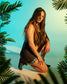 Female athlete kneeling in the RUDIS Hildebrandt 2.0 Women's Wrestling Shoes in Green Leopard with a matching leopard-print singlet, framed by tropical greenery in a vibrant studio setting.