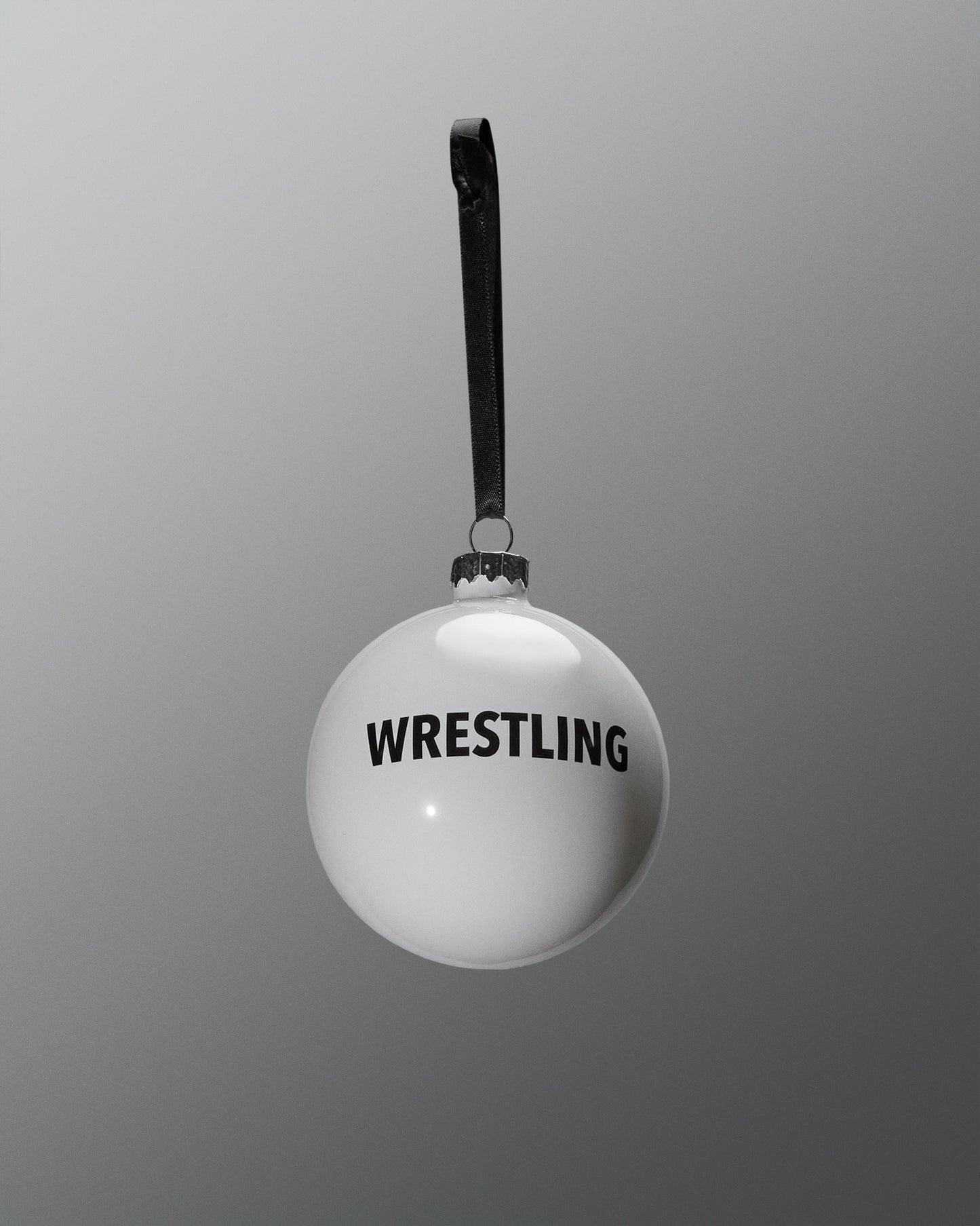 White ball with 'WRESTLING' text and black strap on a gray background