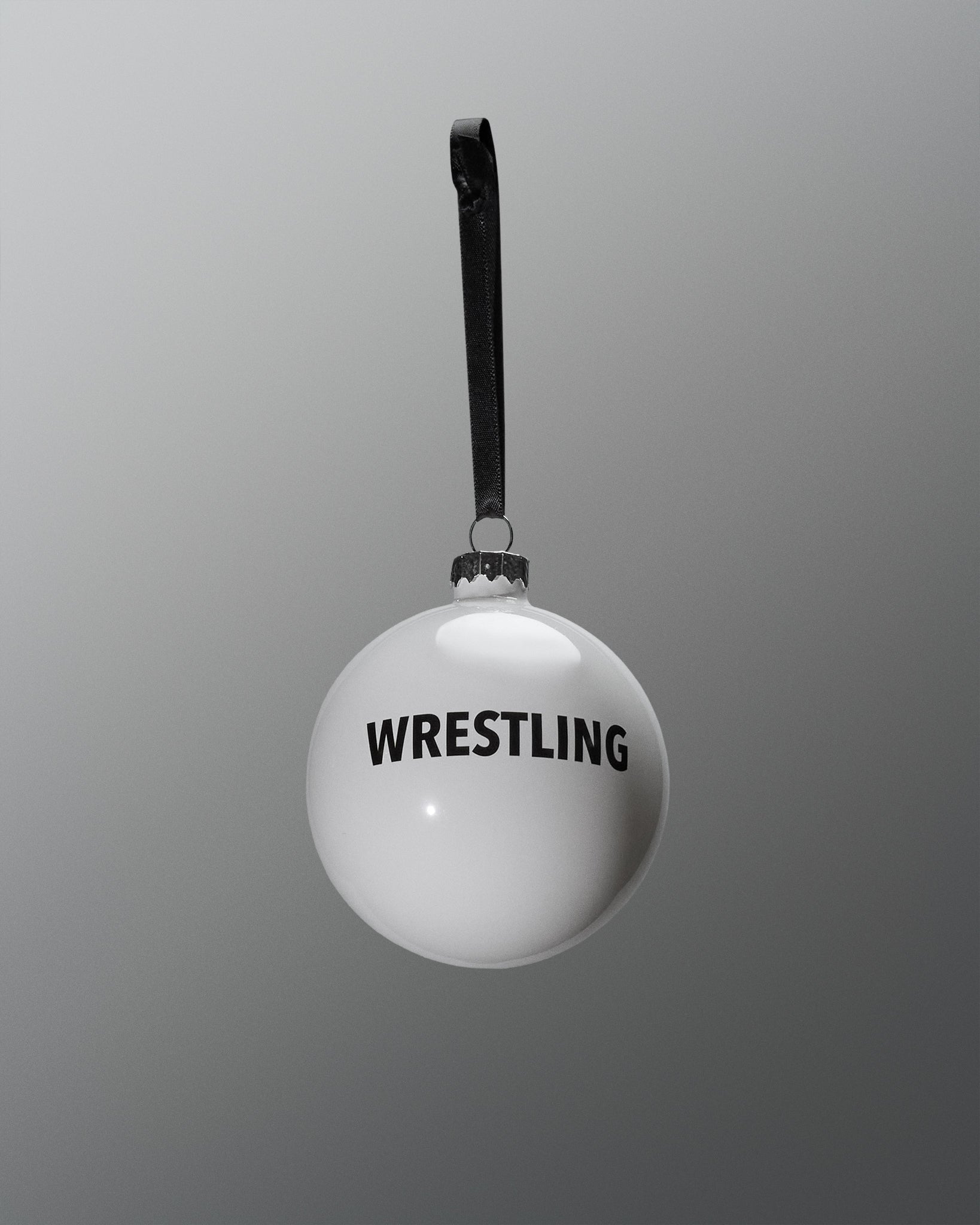 White ball with 'WRESTLING' text and black strap on a gray background