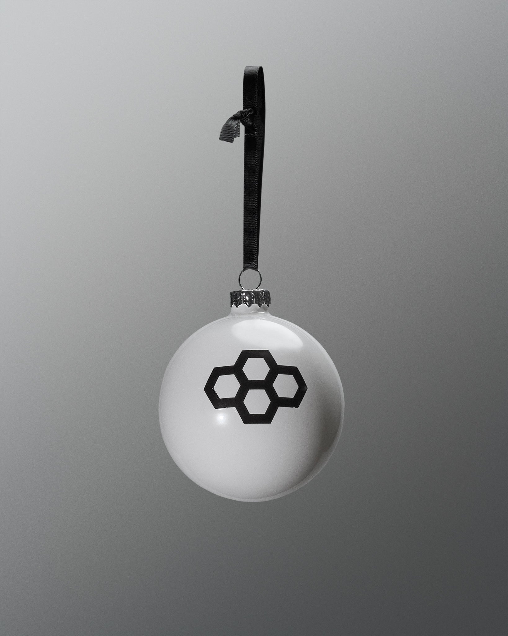 White spherical pendant with black geometric design on a gray background