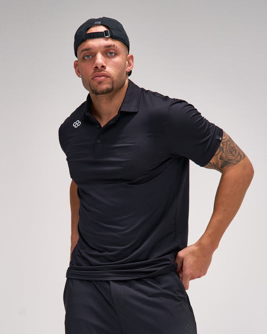 Man wearing a black polo shirt and cap on a gray background