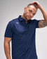 Man wearing a navy blue polo shirt with a logo on a gray background