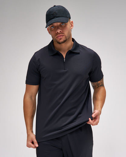 Man wearing a black polo shirt and cap on a gray background
