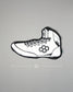 White wrestling shoe pillow with black accents on a gray background
