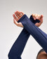 Person wearing a navy blue sleeve on one arm against a light gray background