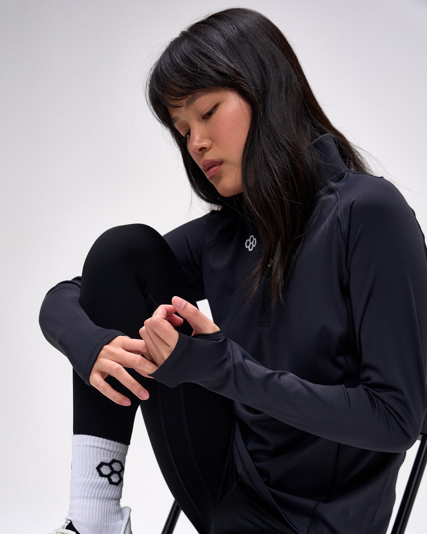 Person wearing a black outfit with a logo on a white background