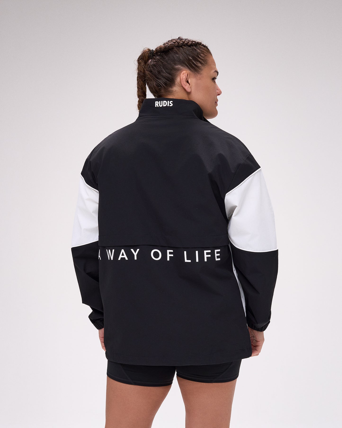 Person wearing a black and white jacket with 'A Way of Life' text on the back, on a plain background.