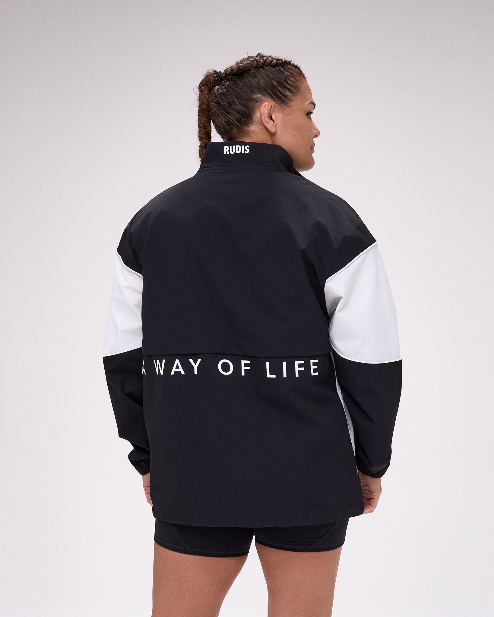 Person wearing a black and white jacket with 'A Way of Life' text on the back, on a plain background.