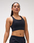 Woman wearing a black sports bra and shorts with a logo on a white background