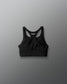 Black sports bra with brand logo on a gray background