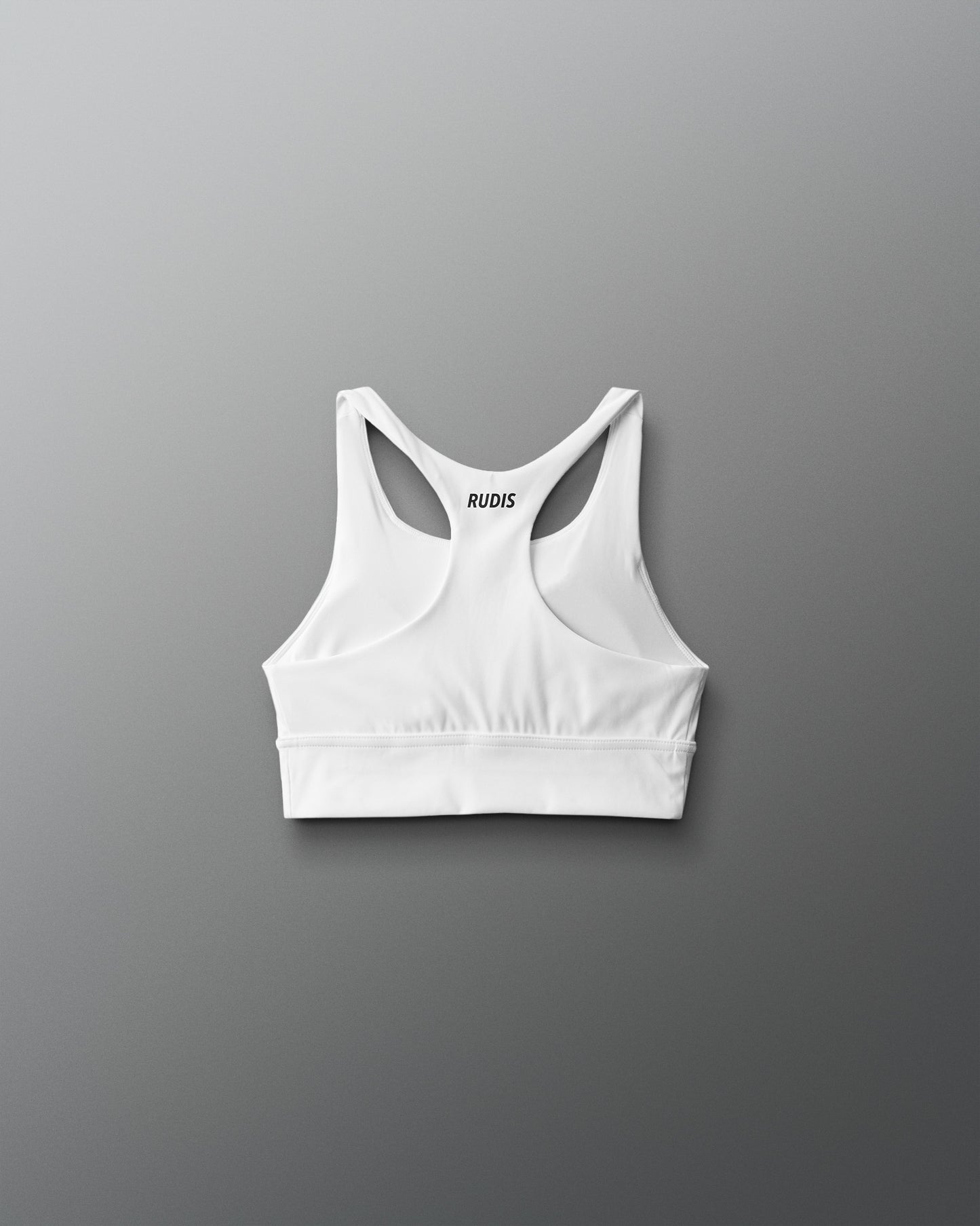 White sports bra with thin straps on a gray background