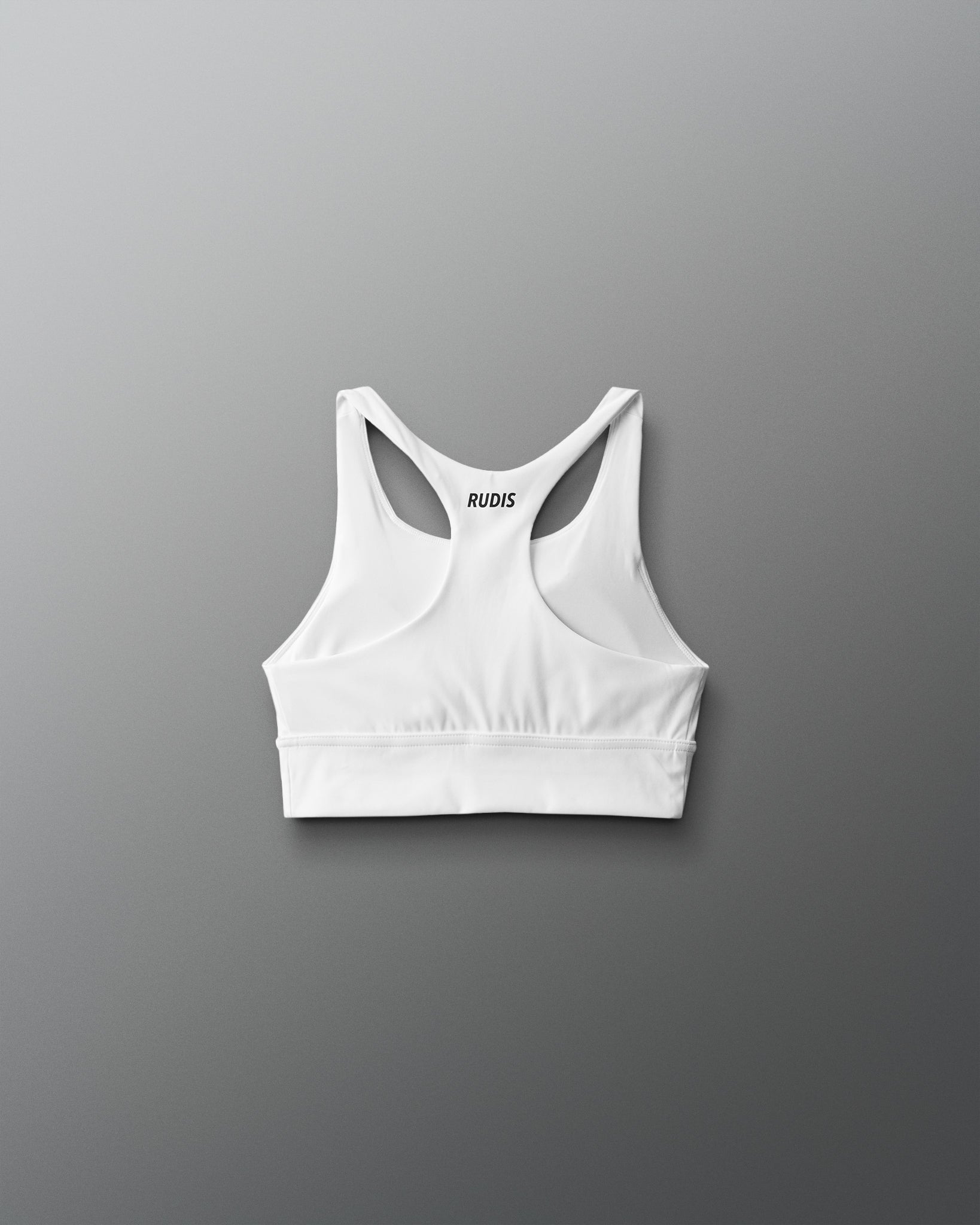 White sports bra with thin straps on a gray background