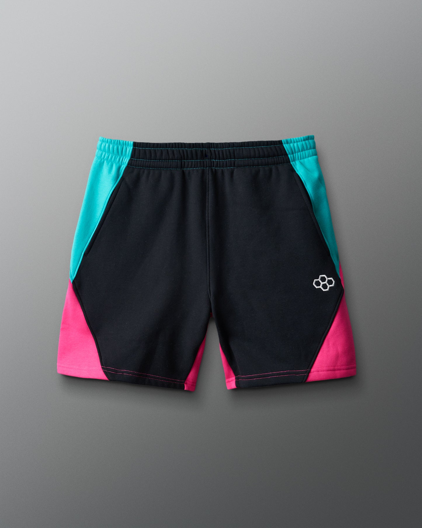 Black shorts with teal and pink sides on a gray background