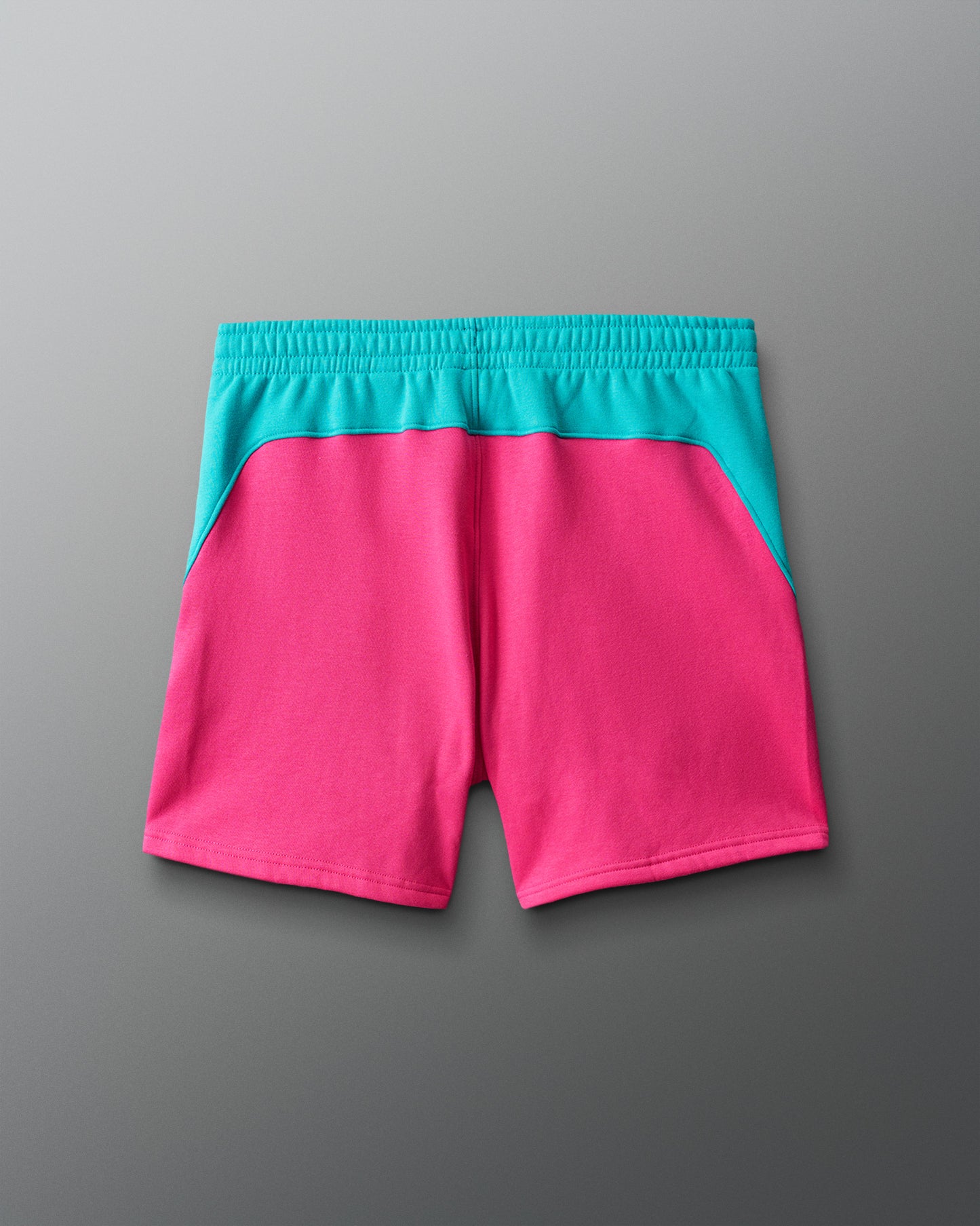 Pink shorts with teal waistband on a gray background