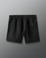 Black shorts with a brand logo on a gray background