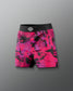 Pink and black patterned shorts with a brand logo on a gray background