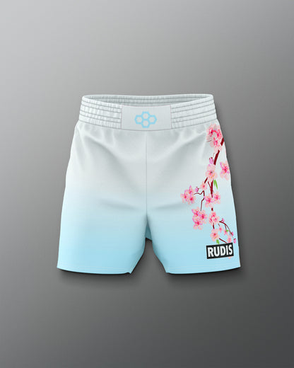 White shorts with cherry blossom design and 'RUDIS' branding on a gray background