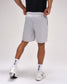 Person wearing gray shorts and white sneakers on a plain background