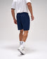 Person wearing navy shorts and white sneakers on a plain background