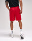Person wearing red shorts, black shirt, white socks, and white sneakers on a light gray background