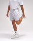 Person wearing white athletic shorts and shoes on a plain background
