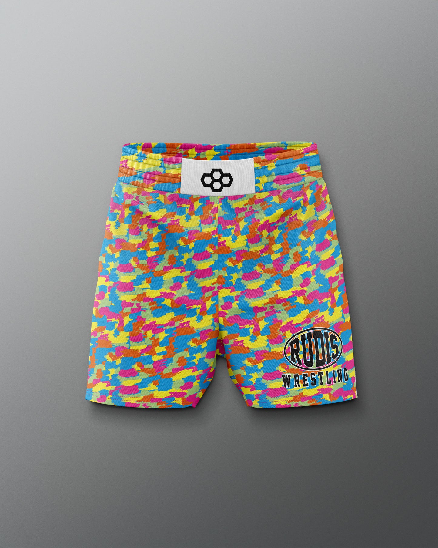 Colorful camouflage wrestling shorts with a brand label on a gray background