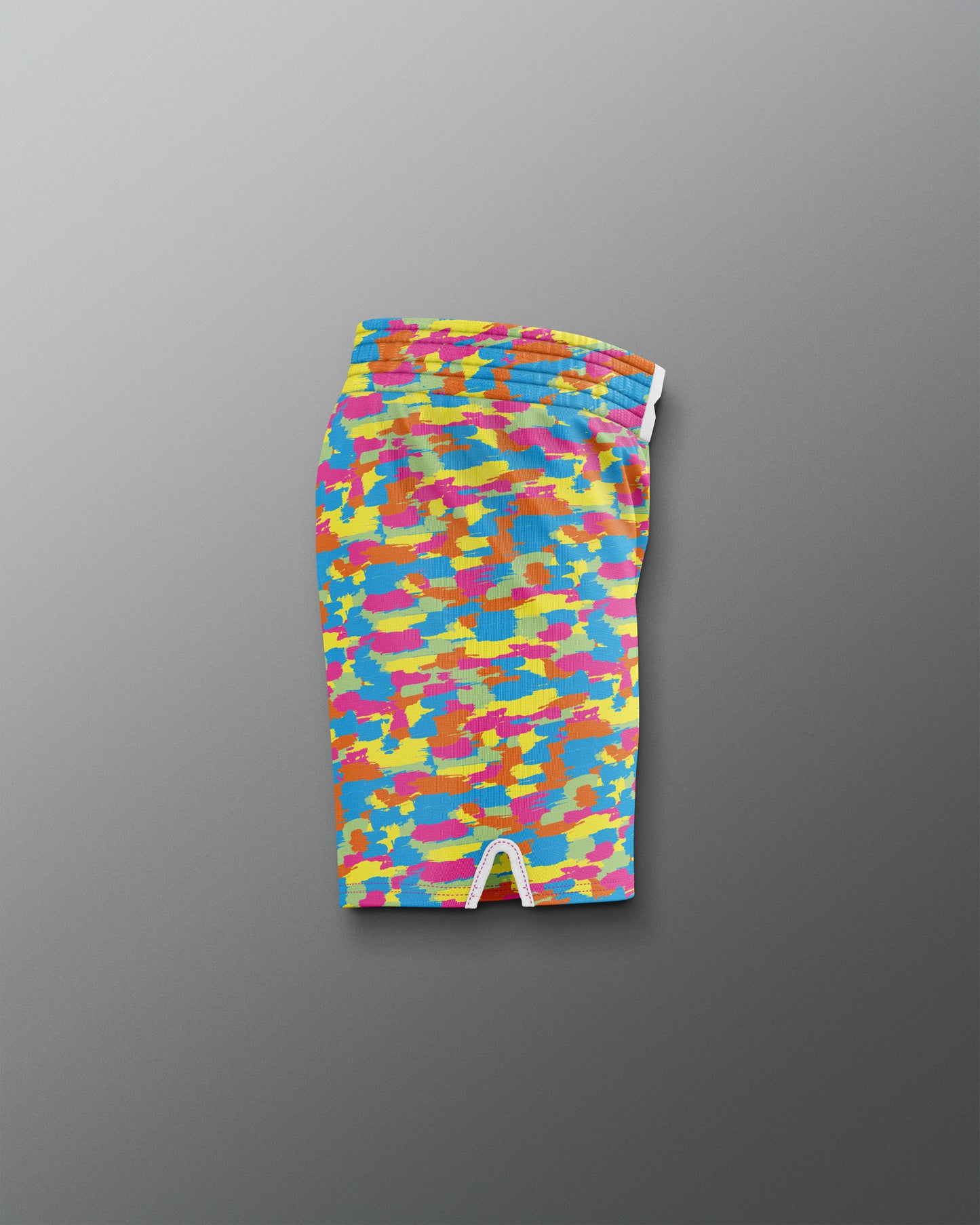 Colorful camouflage-patterned swim shorts on a gray background
