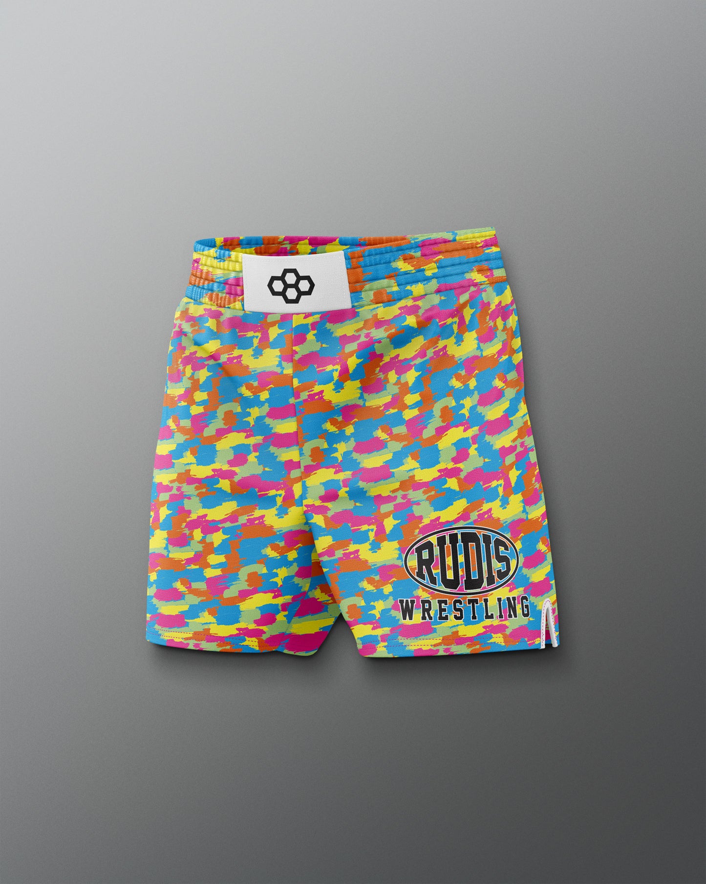 Colorful camouflage wrestling shorts with visible branding on a gray background